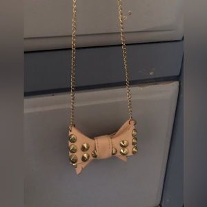 2 necklaces. with embellish gold spikes. One pink one white